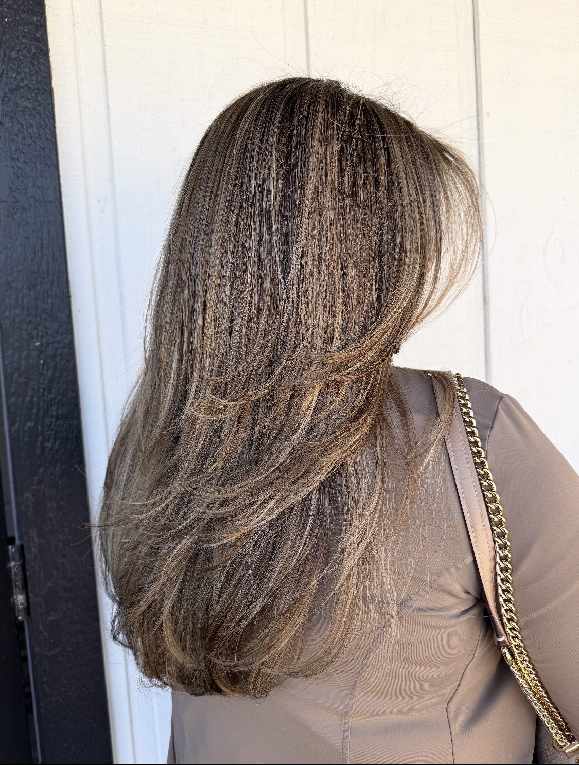 After: cool ash-blonde highlights with a long, layered, face-framing cut