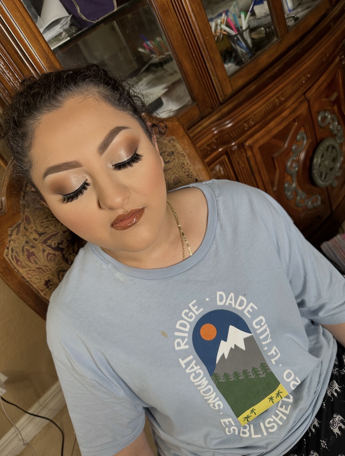 Soft glam makeup with bronze shimmer eyes, full lashes, and a glossy nude lip